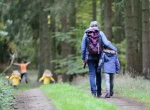 Une famille marche sur un chemin forestier