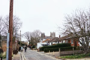 People walking up a street towards a distant cathedral